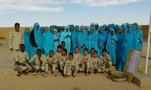 صورة من التلاميذ وهم يلبسون زيهم الموحد ..ويظهر المدير معهم في يسار الصورة